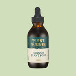 Bottle of Plant Runner indoor plant food on a light green background