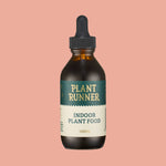 Bottle of Plant Runner indoor plant food on a pink background