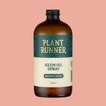 Bottle of Plant Runner Neem Oil Spray on a pink background