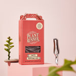 A Box of The Plant Runner's Cacti potting mix set amongst garden accessories